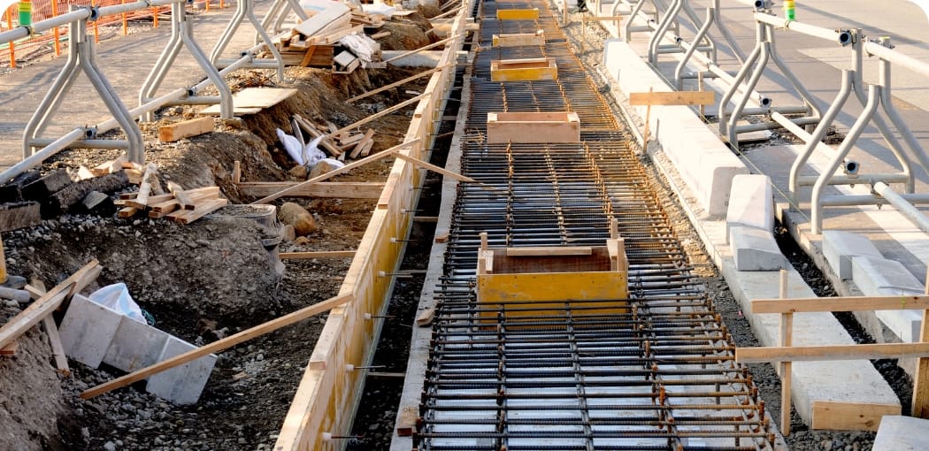 道路脇で行われている基礎工事で、鉄筋が格子状に組まれている様子